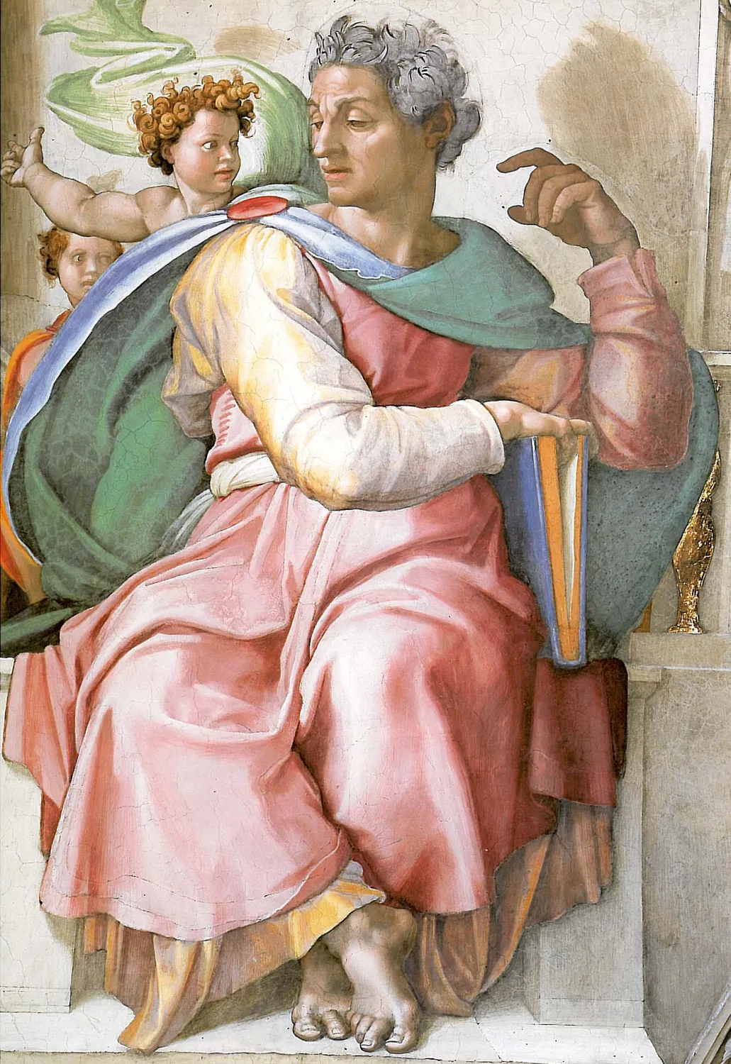 A painted prophet with grey hair sits with a book on his knee, turns his head and lifts one hand. A small child stands behind him.