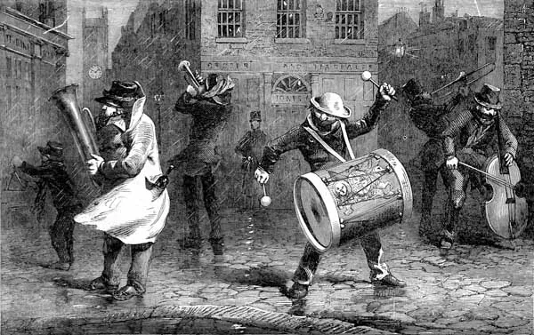 A Victorian wood engraving of street musicians called waits, playing and singing at night in a crowded London street.
